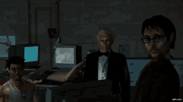 a man in a tuxedo and glasses stands in a dark room with two other men