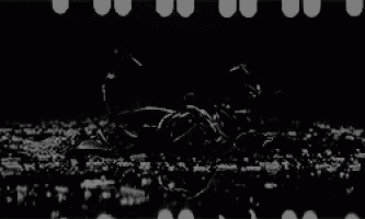 a black and white photo of a person laying on the ground in a field .