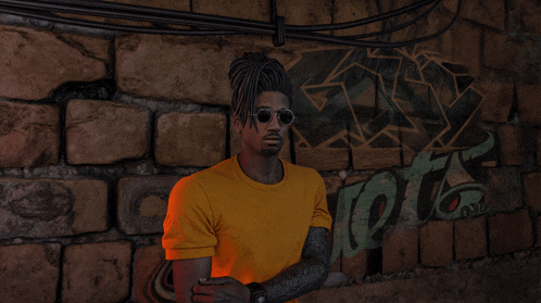 a man wearing sunglasses and a yellow shirt stands in front of a brick wall that has graffiti on it that says shots