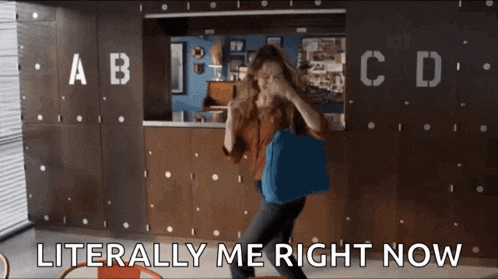 a woman is holding a blue bag in front of a wall that says literally me right now