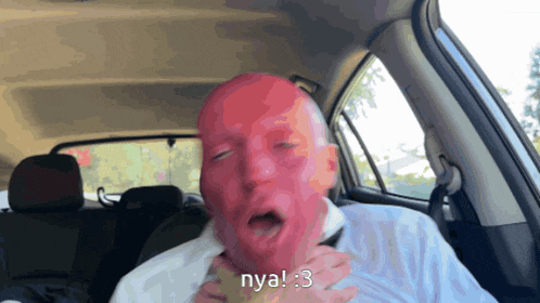 a man with a red face is in the back seat of a car and says nya 3