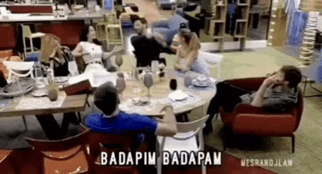 a group of people are sitting around a table in a room with the words badapim badapam written on the bottom
