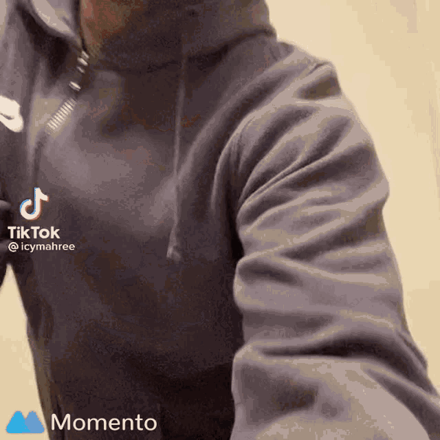 a man wearing a grey nike hoodie takes a selfie