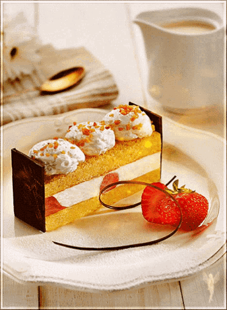 a white plate topped with a piece of cake and a strawberry