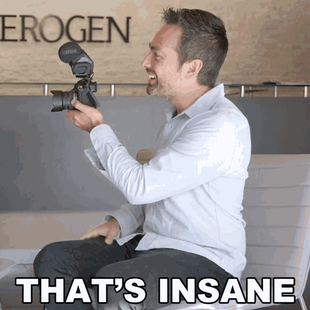 a man holding a camera with the words that 's insane on the bottom