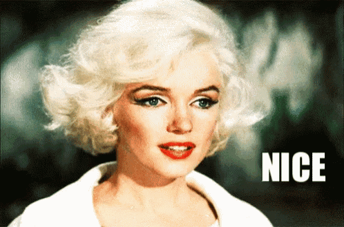 a woman with blonde hair and red lips is standing in front of the word nice