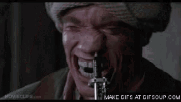 arnold schwarzenegger is smiling and looking at the camera in a gif .