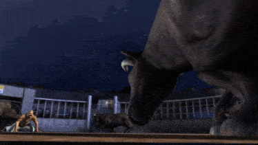 a bull is running in a dark room with a brick wall in the background