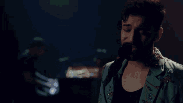 a man with a beard is singing into a microphone