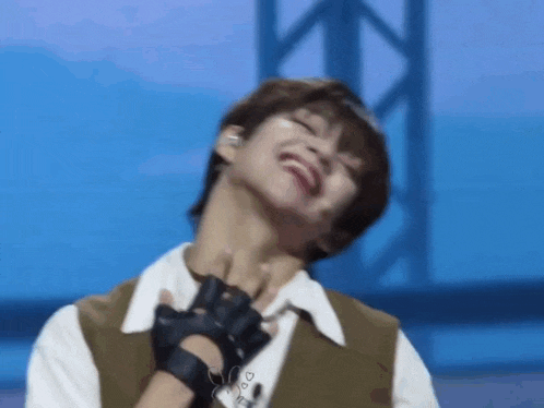 a close up of a person making a funny face while holding their neck .