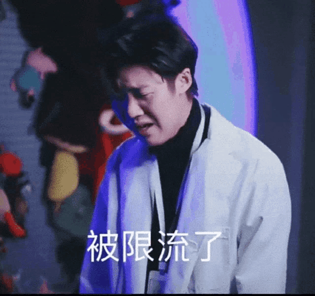 a man wearing a white coat and a black turtleneck has chinese writing on his shirt