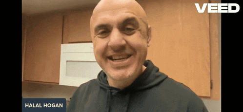 a man is smiling in front of a sign that says halal hogan on it