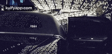 a black and white photo of a car with christmas lights on the side of it .
