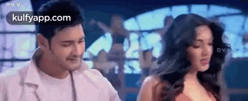 a man and a woman are dancing together in a room in a movie .