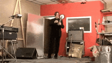 a man playing a guitar in a room with a fender amp