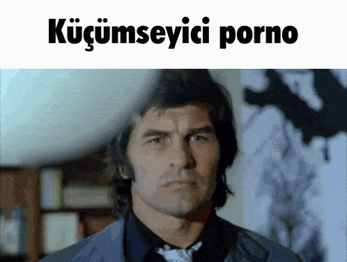 a man in a suit and tie is looking at the camera with the words küçümseyici porno above him .