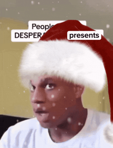 a man wearing a santa hat that says people desper presents on it