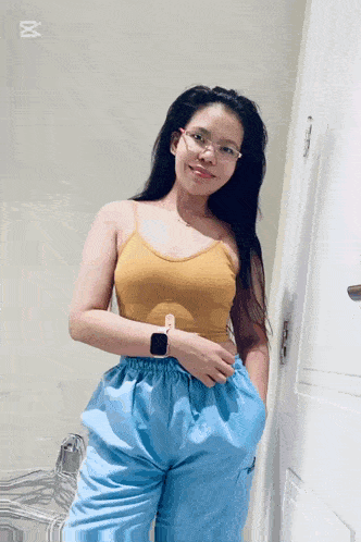 a woman wearing glasses and a yellow tank top