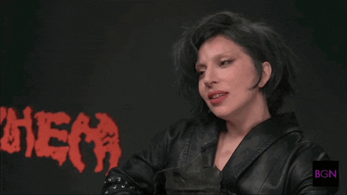 a woman wearing a black leather jacket stands in front of a sign that says hema