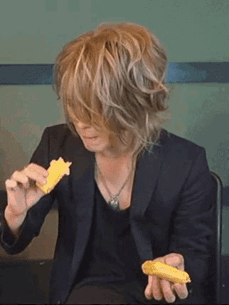 a man in a black jacket is eating a piece of food