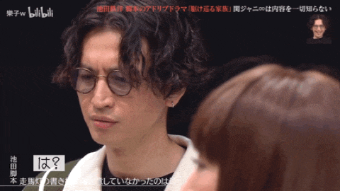 a man wearing glasses is talking to a woman with chinese writing on the bottom