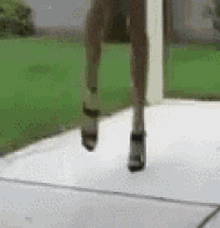 a woman wearing high heels is jumping in the air .