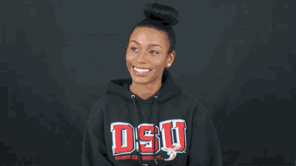 a woman wearing a black sweatshirt with dsu on it