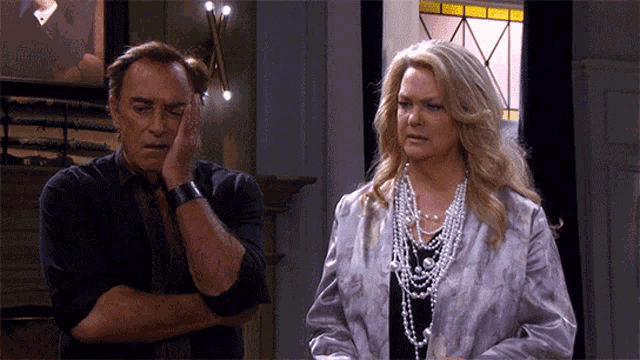 a man and a woman standing next to each other with the woman wearing pearls
