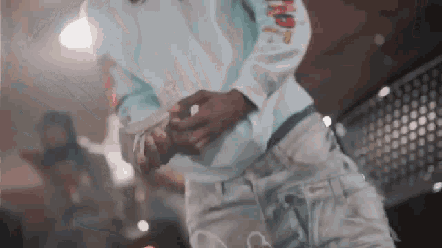 a man is holding a bunch of money in his hands while standing in front of a crowd .