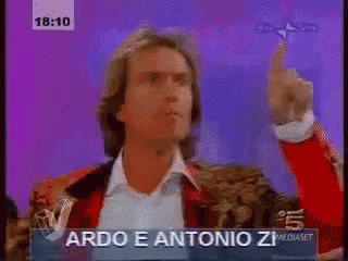 a man in a red jacket is giving a thumbs up in front of a sign that says do e antonio zeq