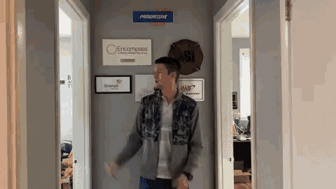 a man stands in a hallway with progressive signs on the wall