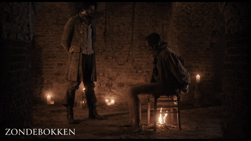 a poster for zondebokken shows a man standing next to a woman sitting on a chair in a dark room