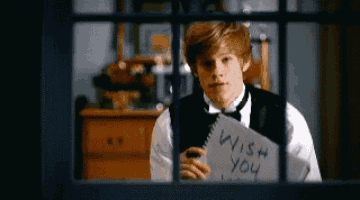a young man is holding a piece of paper that says wish you on it