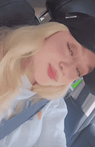 a woman with blonde hair is wearing a black hat and a white shirt