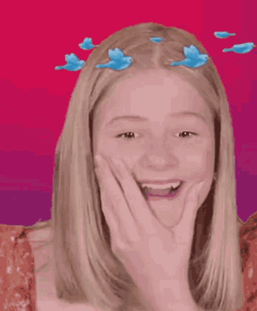 a woman with birds in her hair is laughing and covering her mouth with her hands .