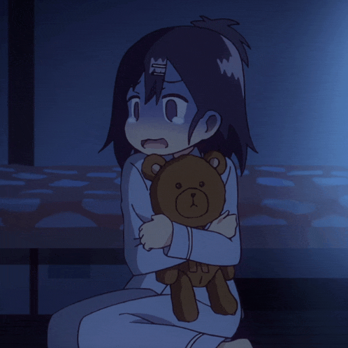a girl is holding a teddy bear in her arms and has the letter u on her head