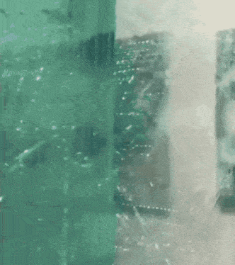 a close up of a broken glass window with a skull in the background