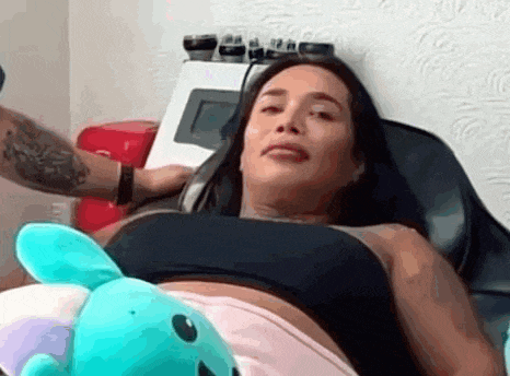a woman is sitting in a chair with a stuffed animal on her belly .