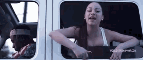 a woman is sitting in the back seat of a car with her arms out the window .