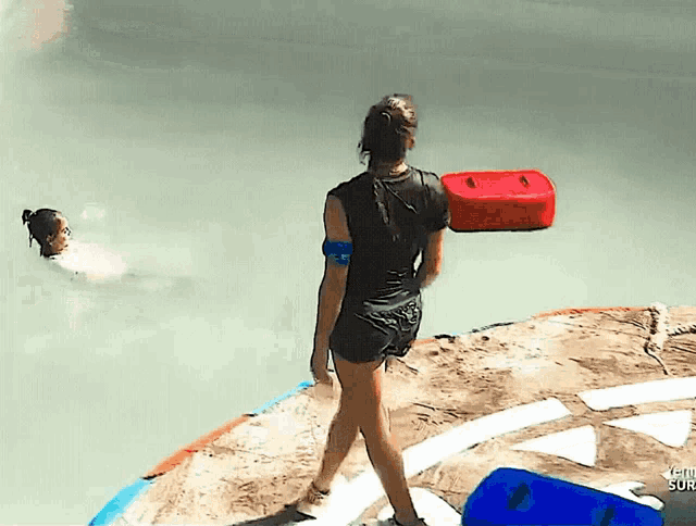 a woman is standing on a rock near a body of water and the word survivor is on the bottom