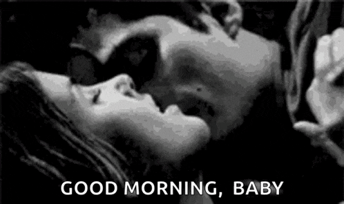 a man and a woman are kissing in a black and white photo with the words `` good morning , baby '' .