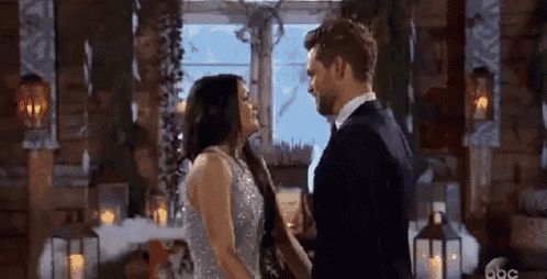 a man and woman are dancing in a room with candles .