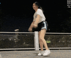 a woman is dancing in front of a fence with a sign that says $ 15 / 4 $ 25 / 7
