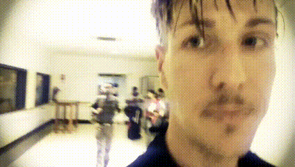 a blurry picture of a man 's face with a few people in the background
