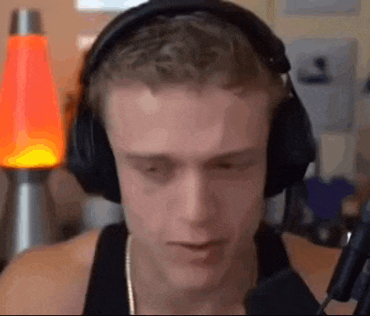 a man wearing headphones is sitting in front of a microphone in a room .