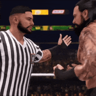 a referee in a striped shirt is talking to a wrestler