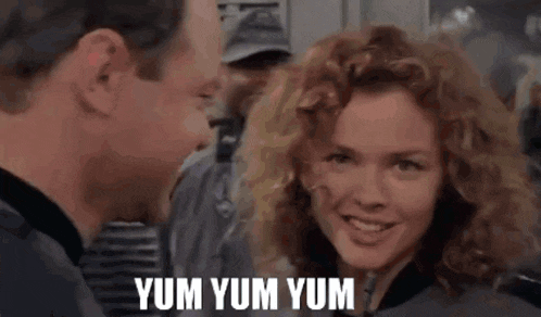 a man and a woman are looking at each other with the words yum yum yum written on the bottom .