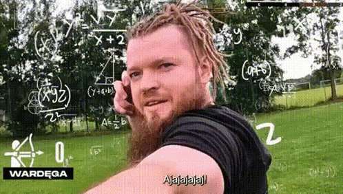 a man with dreadlocks and a beard is talking on a cell phone in front of a chalkboard with math equations on it