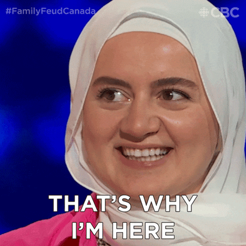 a woman in a hijab is smiling and saying that 's why i 'm here