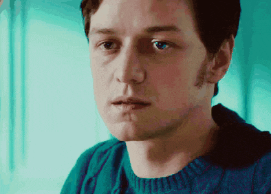 a close up of a man 's face with a blue sweater on